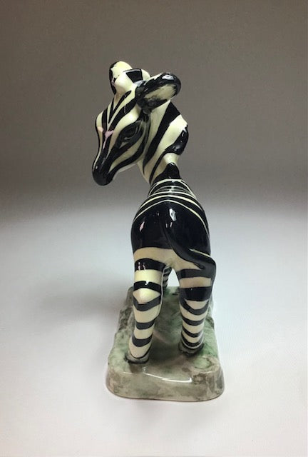 Ceramic zebra figurine on a plain background