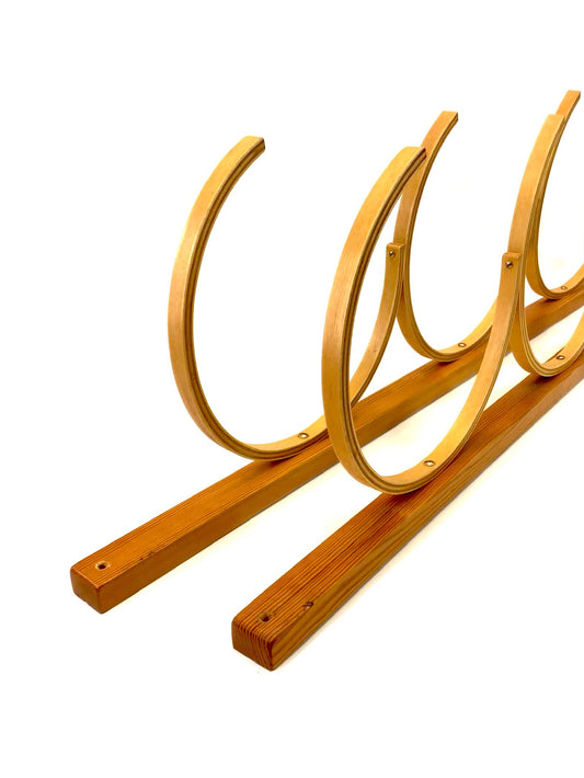 Wooden bike rack with curved design on a white background