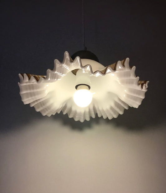 Light fixture with gear-like design on a dark background