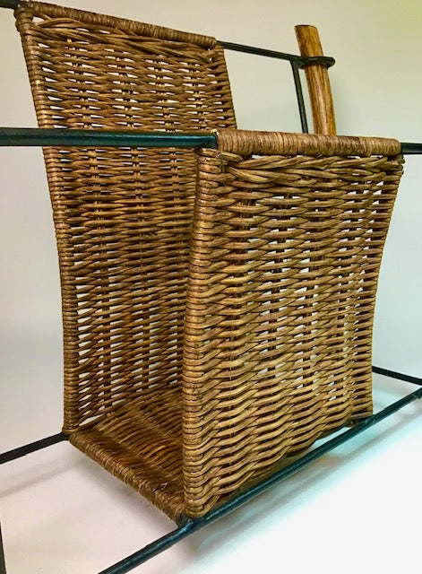Wicker magazine holder on a stand with a plain background