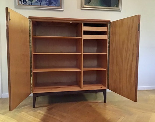 Wooden cabinet with open doors on a wooden floor