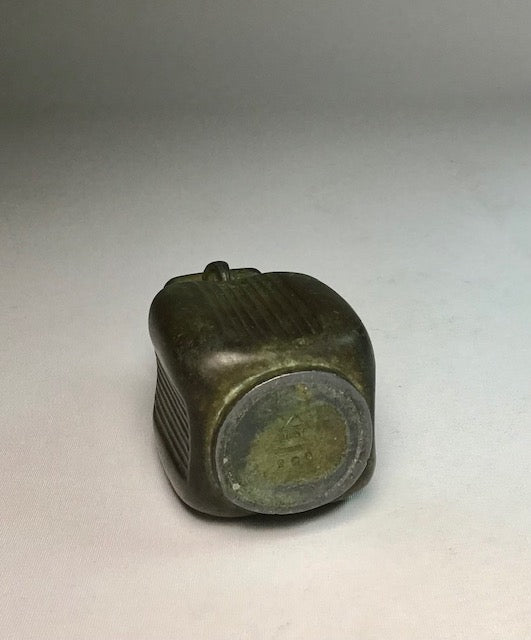 Bronze object with a ribbed texture on a gray background