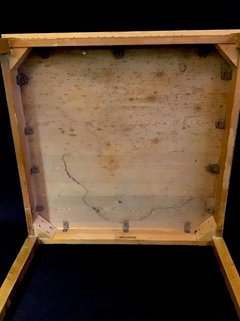 Back view of a wooden picture frame with visible wood grain and hardware.
