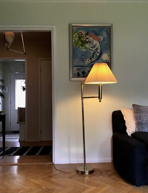 Living room with a lamp, sofa, and painting on the wall.