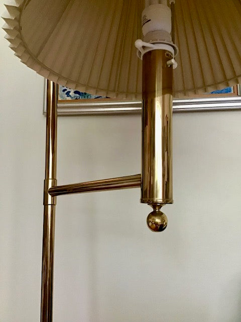 Gold lamp with pleated beige shade on a white background
