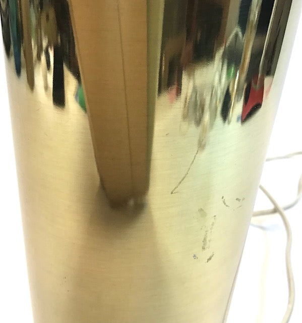 Close-up of a shiny metallic object with reflections on a white background