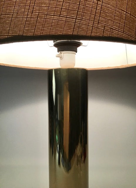 Close-up of a lamp with a brown shade and metallic base.