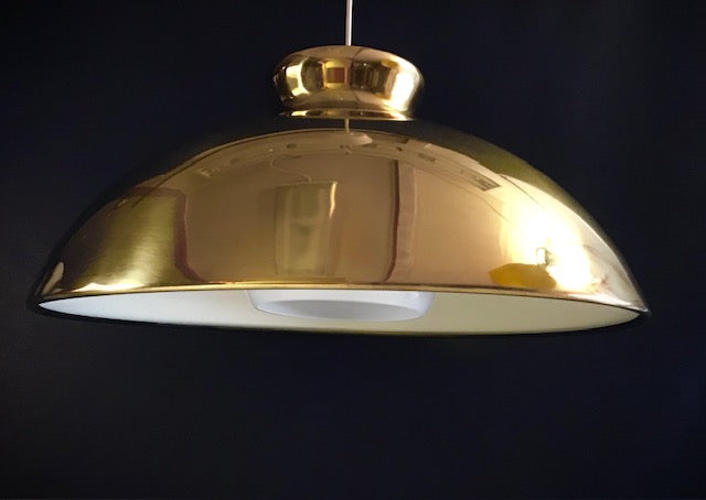 Gold pendant light against a black background