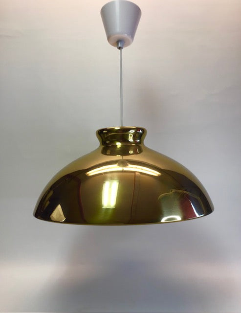 Gold pendant light against a plain background