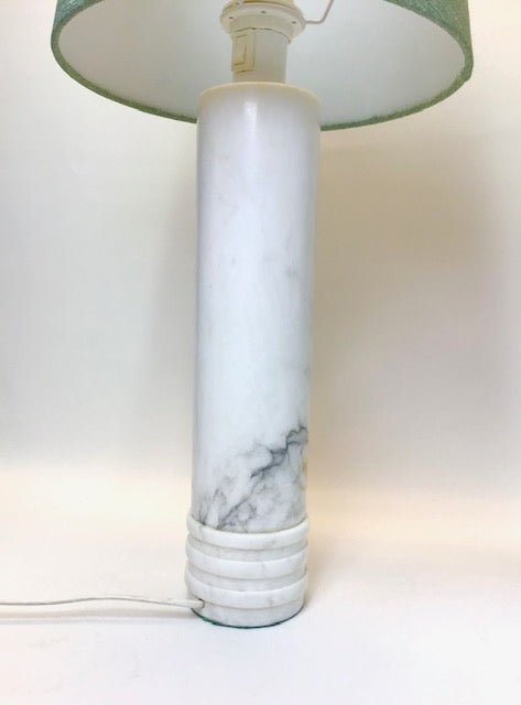 Marble-textured lamp with a green lampshade on a white background