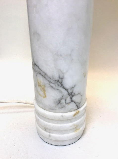 Marble-patterned cylindrical object with a power cord on a white background