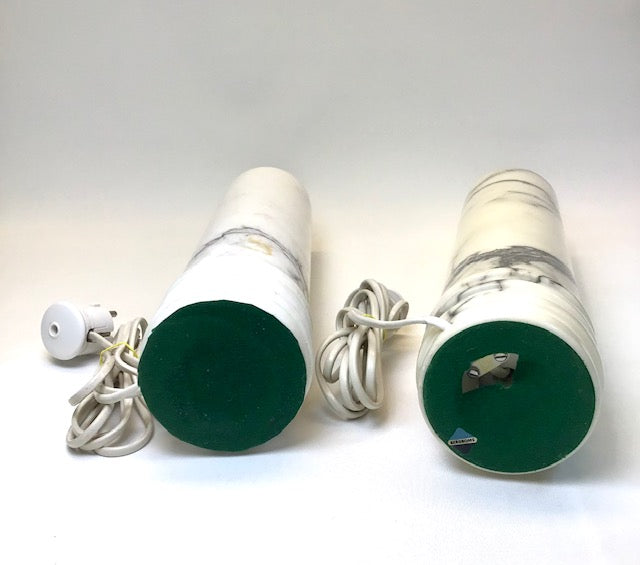 Two green light bulbs with white bases on a white background