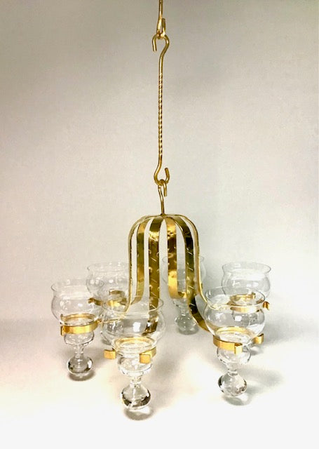 Gold chandelier with glass shades on a beige background