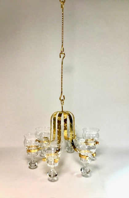 Gold chandelier with glass shades on a plain background