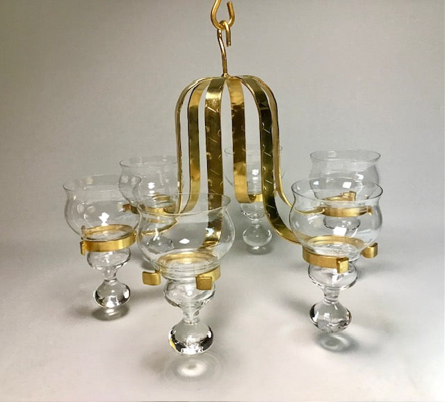Gold and clear glass chandelier on a light gray background