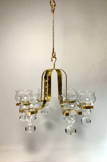 Gold chandelier with clear glass shades on a plain background