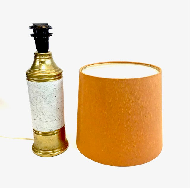 Decorative lamp with gold base and white textured section next to an orange lampshade on a white background