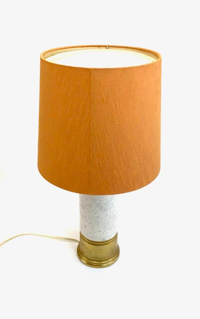Table lamp with an orange shade and white base on a white background