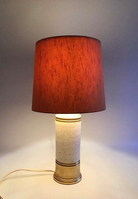 Table lamp with a red shade on a neutral background