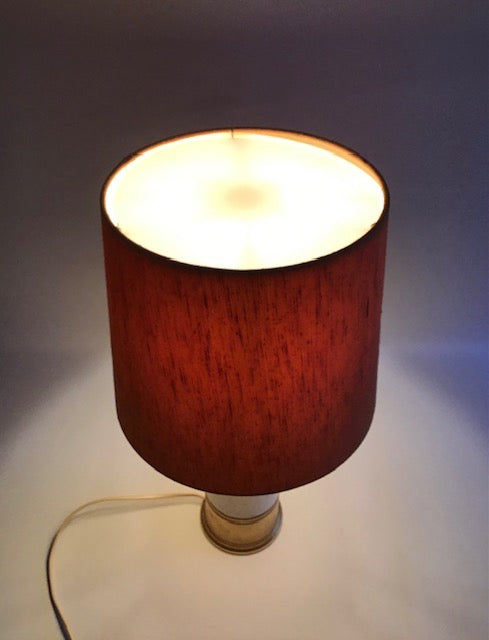 Lamp with a red shade on a neutral background