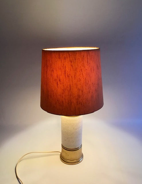 Table lamp with a red shade on a neutral background