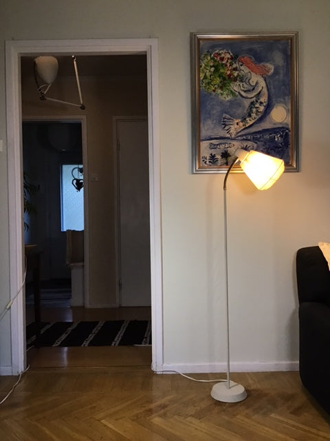 Hidden compartment in a wall with a lamp and painting above it