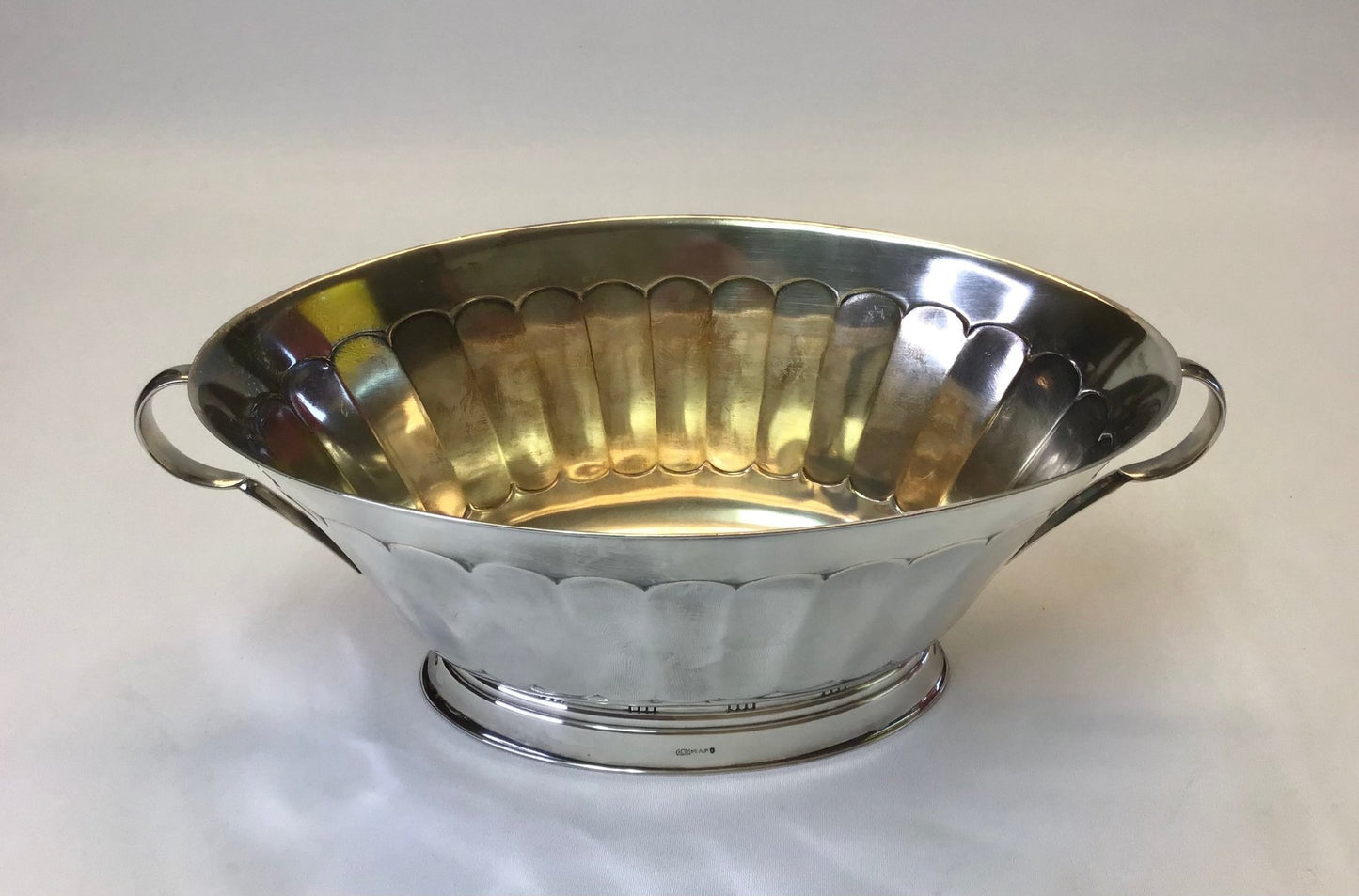 Silver metal bowl with handles on a white background