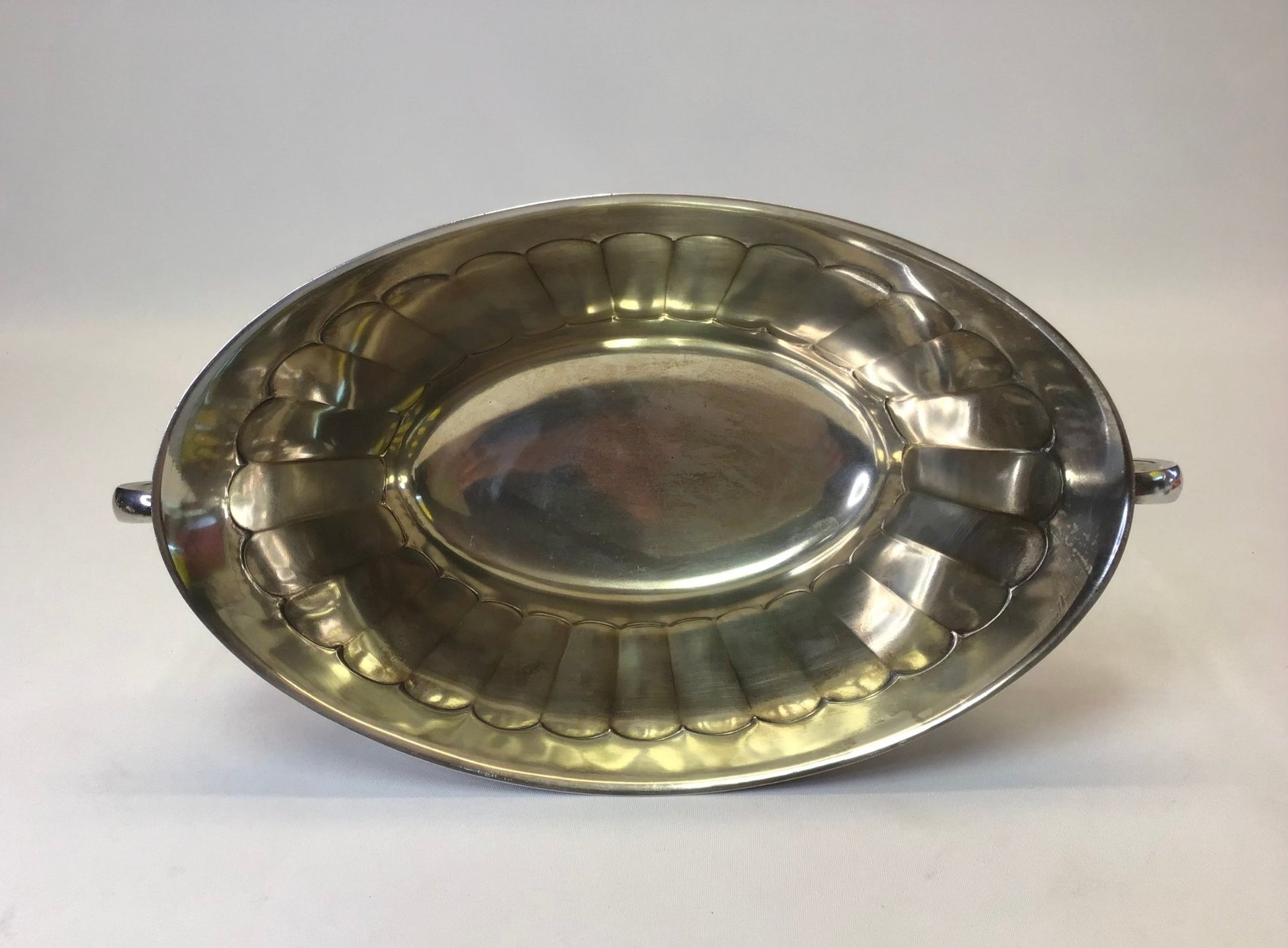 Silver metal tray with decorative edge on a white background