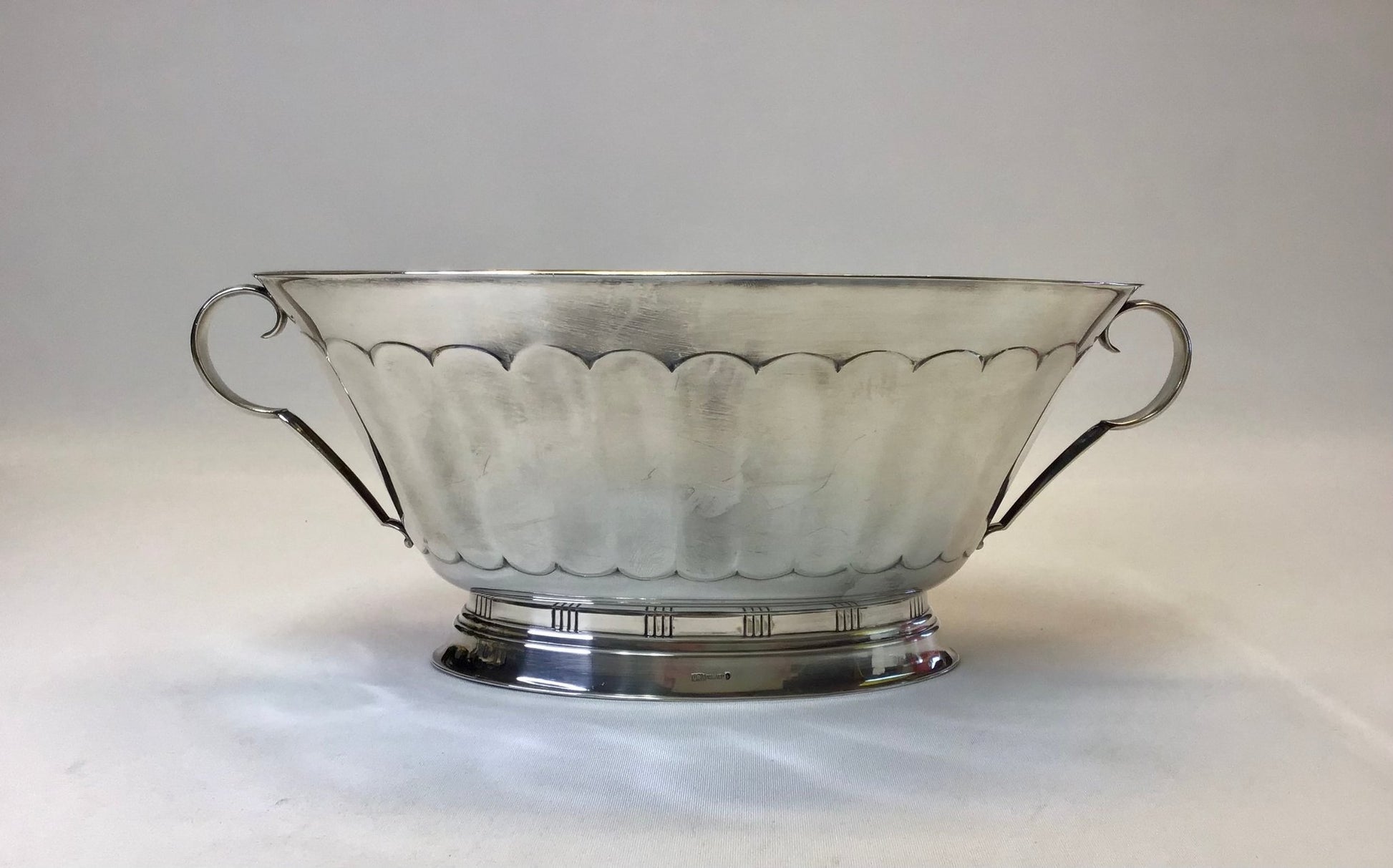 Silver bowl with scalloped edge on a white background