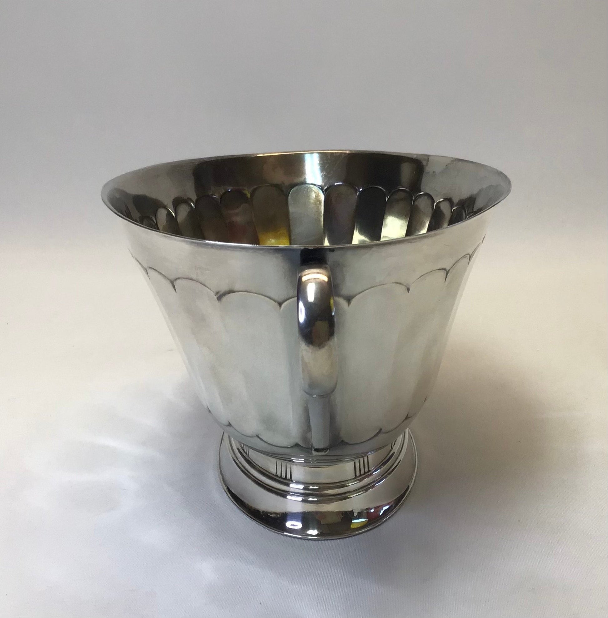 Silver cup with decorative patterns on a white background