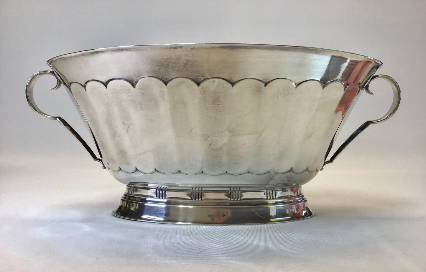 Silver bowl with scalloped edge on a white background