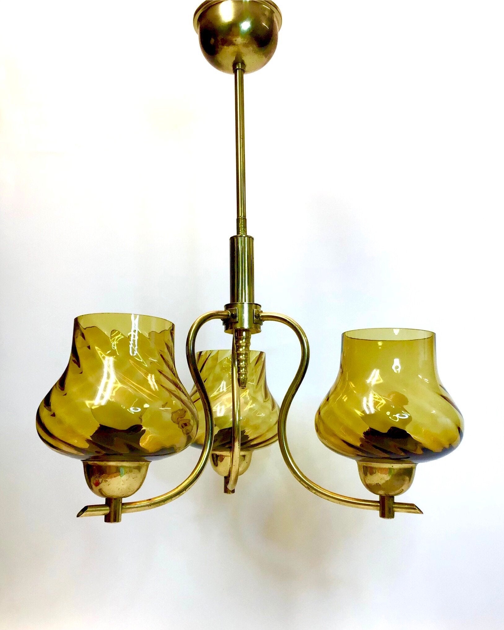 Vintage-style chandelier with three green glass shades on a white background