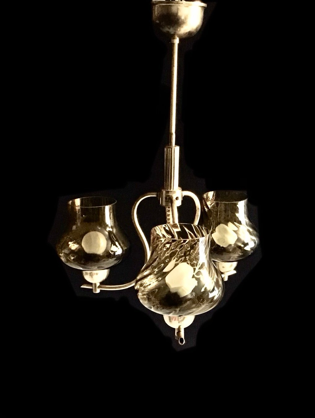Vintage-style chandelier with glass shades on a black background