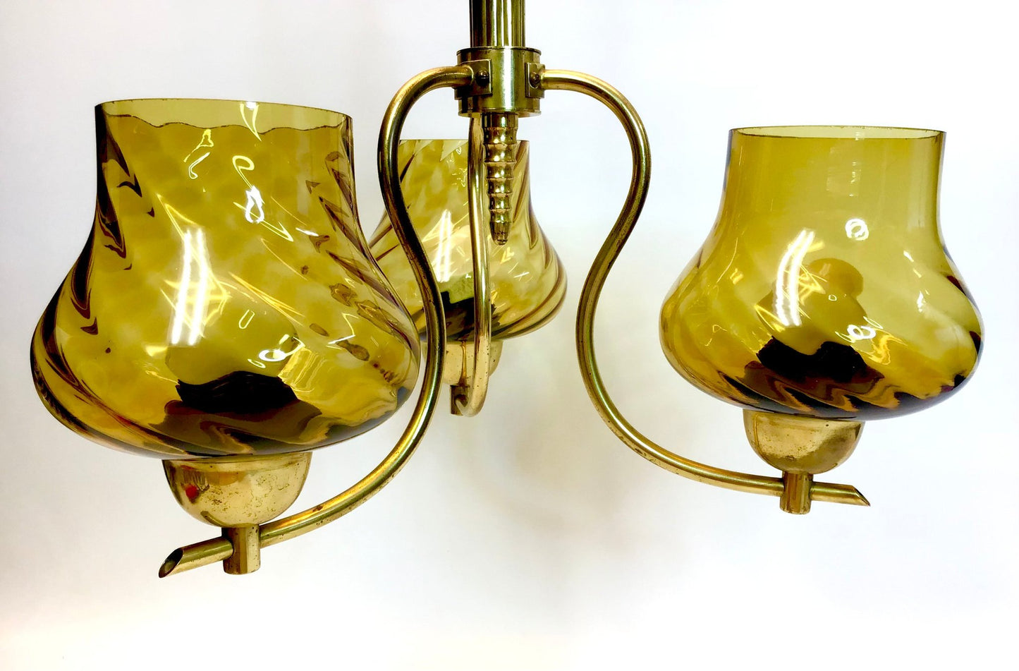 Chandelier with three amber glass shades on a white background