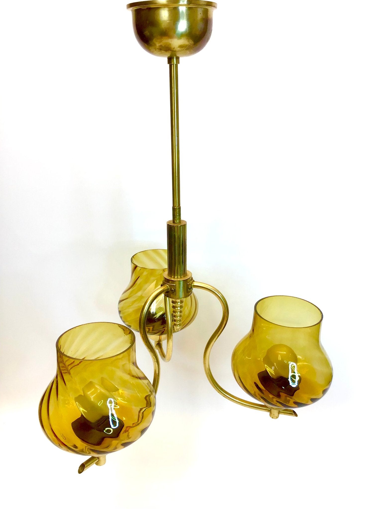 Brass ceiling light fixture with yellow glass shades on a white background