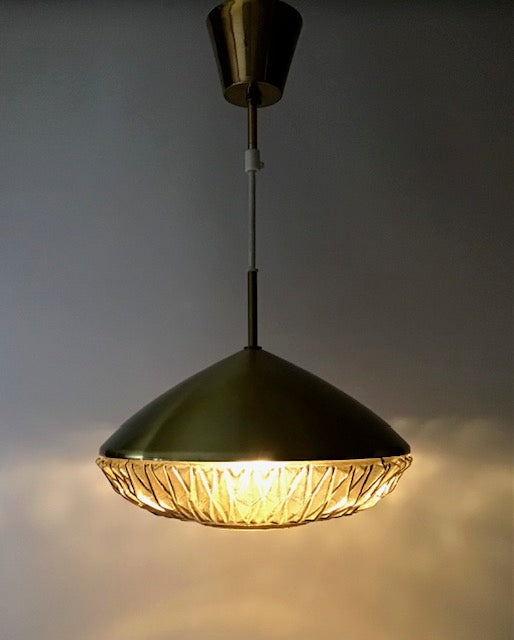Modern pendant light with textured glass shade on a gray background