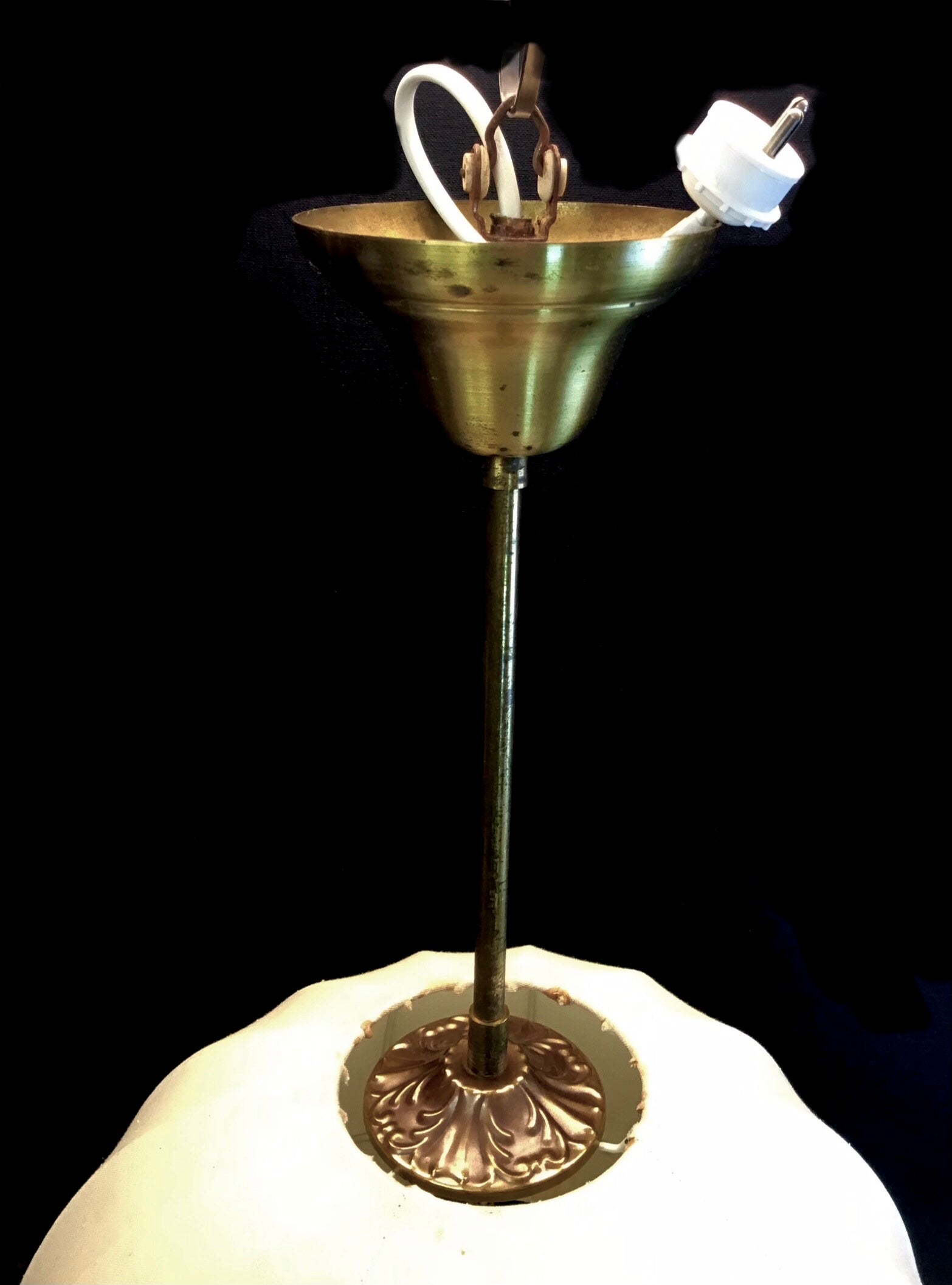 Brass lamp with white glass shade on a black background