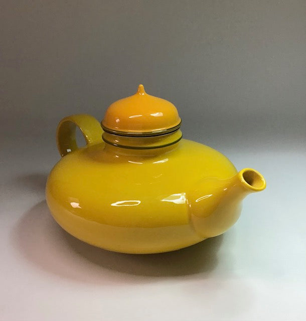Yellow teapot on a gray background