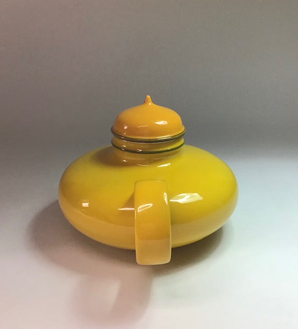 Yellow container with a lid on a light gray background
