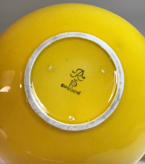 Yellow ceramic bowl with a visible brand logo and 'Sweden' text on the base.