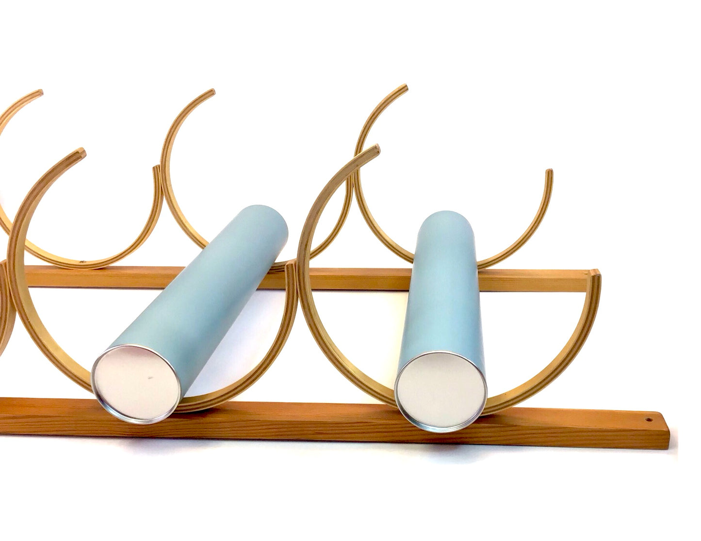 Decorative wall piece with gold arches and light blue cylindrical candles on a white background