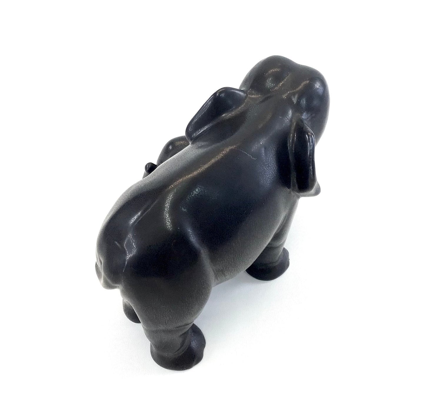Black stone sculpture of a bear on a white background