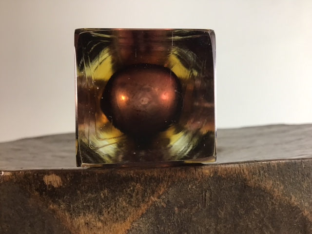 Decorative glass block with a multicolored pattern on a wooden surface