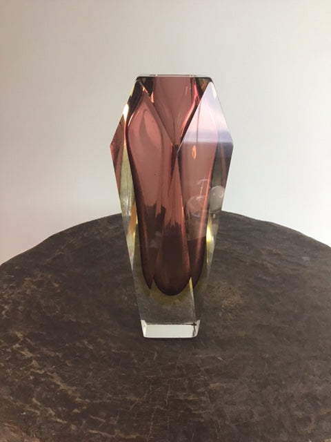 Crystal-like object on a wooden surface with a neutral background