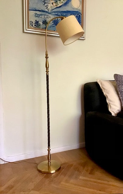 Floor lamp with a beige shade in a living room setting.