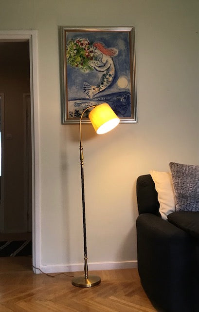 Living room with a floor lamp, sofa, and wall art