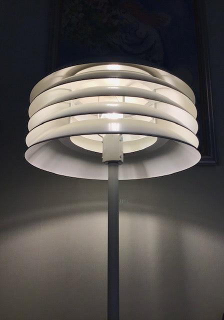 Modern floor lamp with cylindrical design on a dark background