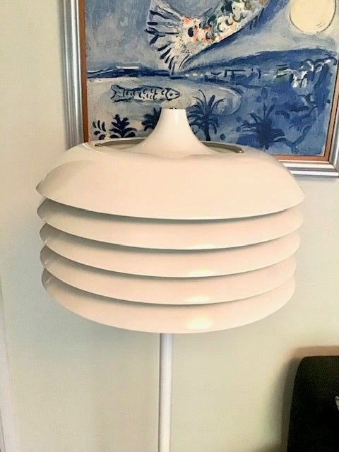 White pendant lamp with a decorative painting in the background