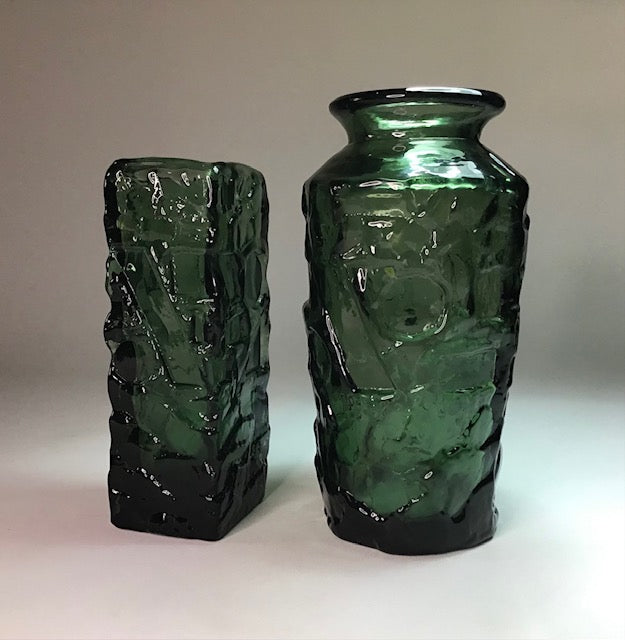 Two green textured vases on a plain background
