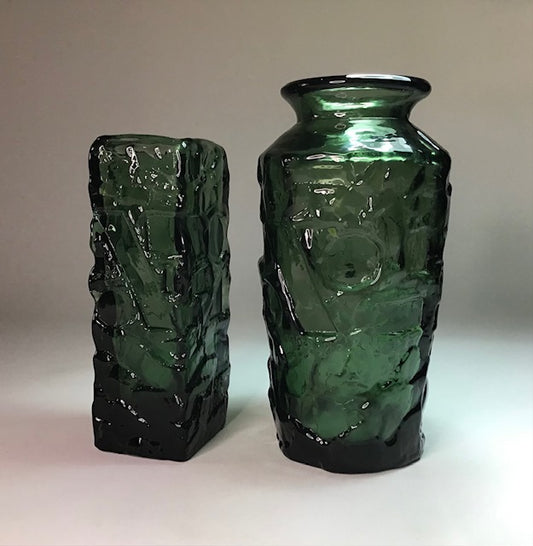 Two green textured vases on a plain background
